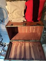 Open steamer trunk showing cedar interior, blankets on lid