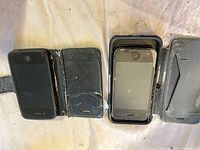 Two iPhone 3-series phones in wallet cases, fronts visible