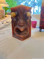 Brown tiki face candle, showing shape and burn residue