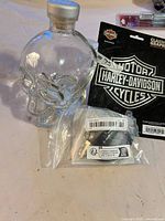 Glass skull bottle, Harley-Davidson decal card, sealed black hardware part