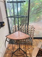 Full view of plant stand showing three tiers and metal scroll frame