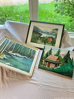All three paintings grouped together showing frames and canvas