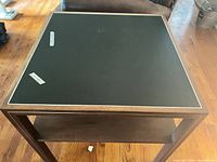 Top view showing black laminate surface with metal trim and masking tape measurement notes