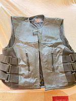 Front of black leather motorcycle vest with zip pockets and adjustable side straps
