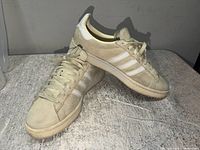 Left and right Adidas Campus 00s sneakers on side; shows uppers and overall wear
