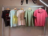 Front view of all five shirts on hangers