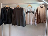 Four sweaters hanging on rack