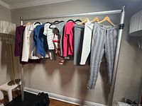 Full view of ten garments on hanging rack