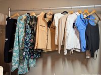 Rack showing entire assortment of 11 medium women’s tops and bodysuit