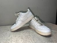 Lateral view of both shoes showing overall condition and white leather uppers