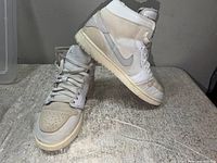 Side and angled view of both sneakers showing colorway, materials, and outsole wear