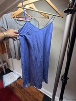 Full view blue slip dress and partial grey dress on hangers