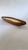 Full view of boat-shaped wood candle