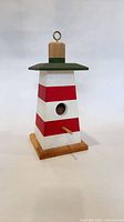 Full view of lighthouse birdhouse showing colors, perch and base