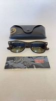 Sunglasses, hard case, sealed cleaning cloth front view