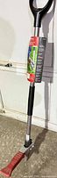 Full view of Alterra weeder showing D-handle, shaft, foot pedal and packaging