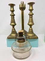 Pair of brass candlesticks, brass lamp stand and separate clear glass reservoir