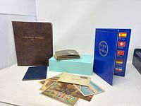 Overall view of coin albums, scrapbook, passport and postcards