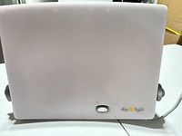 Front view of white Daylight therapy lamp showing logo, power button, side adjustment knobs, attached cord