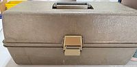 Closed tackle box front view showing latch, color and wear