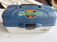 Closed tackle box front view showing logo, latch, handle