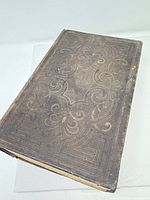 Front cover showing leather binding with ornate blindstamped design and wear