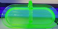 Top view of uranium glass tray glowing under UV light