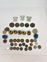 Full lot laid out showing variety of coins, tokens and key fobs