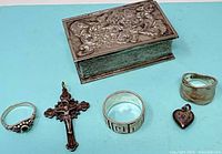 All items: floral trinket box, crucifix pendant, three rings, heart charm