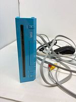 Front view blue Wii console with AV cable and accessories