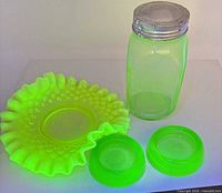 Full set showing ruffled bowl, jar with lid, two small dishes under UV light