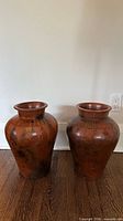 Front view showing both large terracotta vases side by side