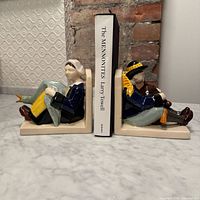 Pair of Quimper bookends holding a reference book between them