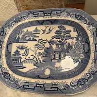 Front view of blue and white oval platter showing full Blue Willow pattern