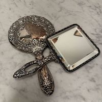 Both hand mirrors front view showing shapes and ornate handles