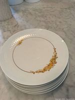 stack of small plates showing gold scroll border