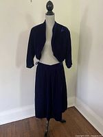 Full view of bolero jacket on dress form with matching skirt