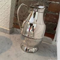 Full view of silver metal Thermos jug on countertop