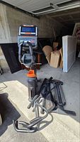 Console, handles and disassembled parts of elliptical in garage