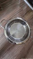 Top view of round stainless steel buffet server with dual handles