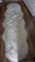 Full view of white faux sheepskin runner rug on floor