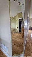 Four of the six Krabb mirror panels installed vertically on wall showing wavy edges