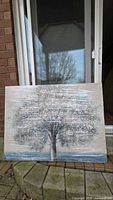 Front view of wrapped canvas showing tree artwork leaning against sliding door