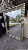 Front view of oversized mirror showing entire ribbed metallic frame and glass