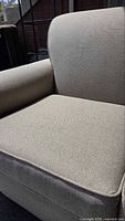 Close view of right arm and seat cushion showing fabric texture and condition