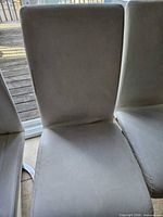 Front view of one chair showing upholstery wear