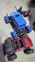 Blue and red RC off-road trucks showing bodies, wheels, and overall condition
