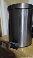 Closed stainless steel trash can showing pedal