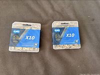 Front view of two sealed KMC X10 chain boxes