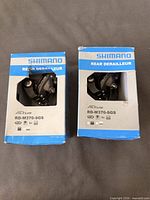 Front view of both boxed Shimano rear derailleurs